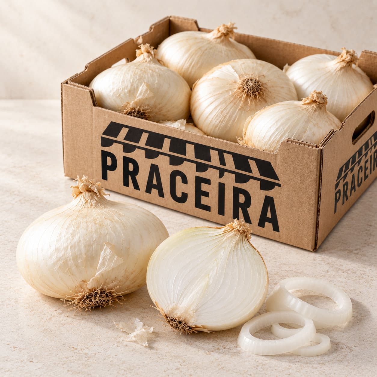 Una cebolla blanca entera, otra partida por la mitad con sus capas a la vista y unos aros sueltos